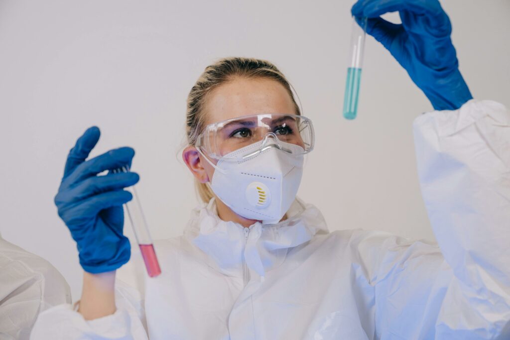A Person Wearing Safety Goggles Looking at the Test Tubes